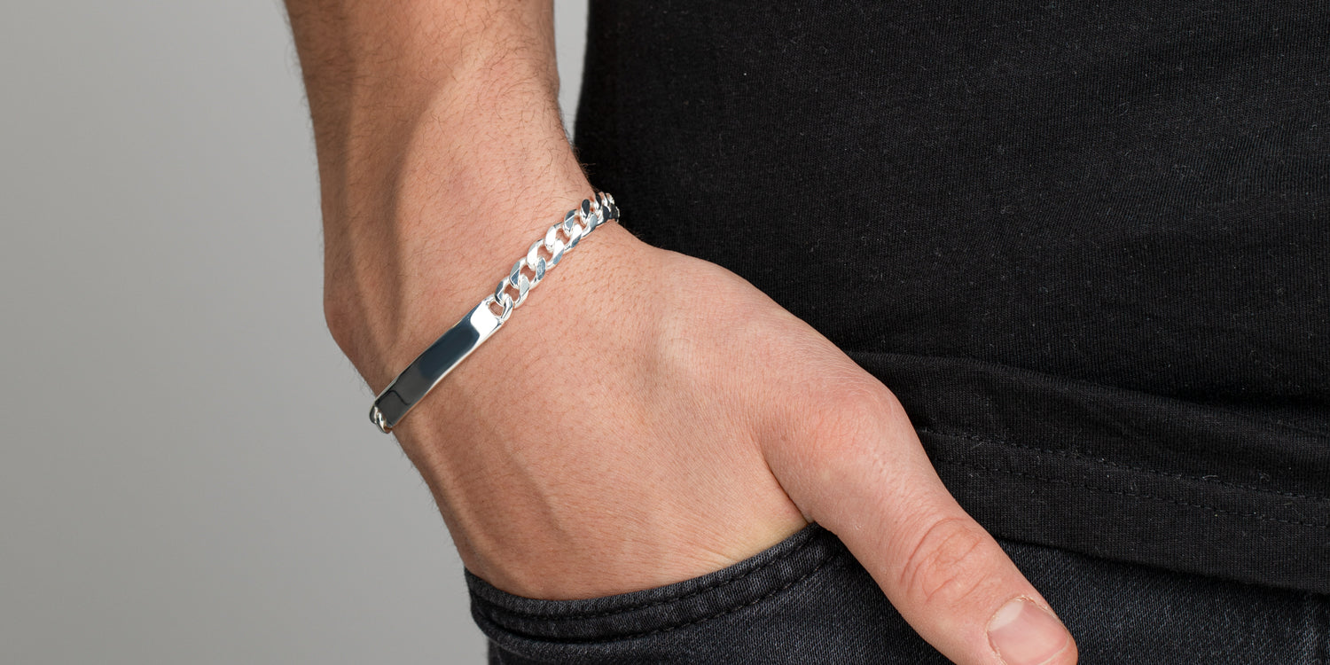 Silbernes Panzerarmband mit Gravurplatte am Handgelenk getragen